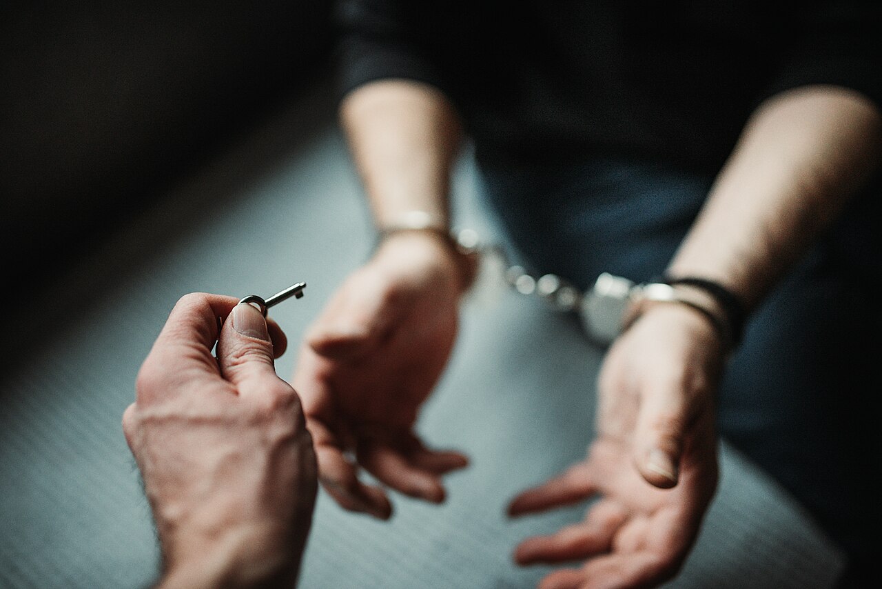 Person holding a metal key in front of a closed safe